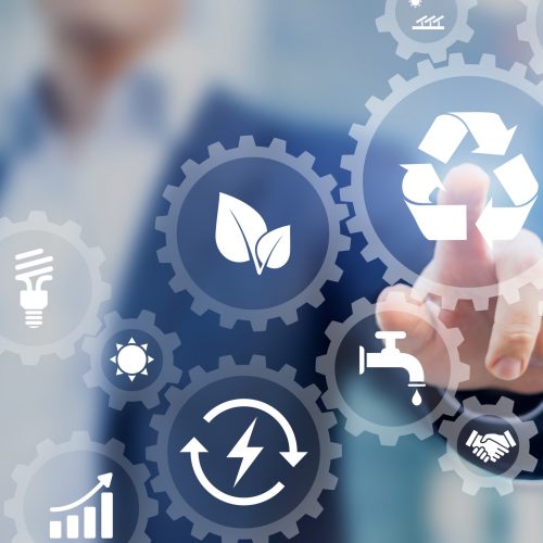 Sustainable development concept on screen with icons of renewable energy Sustainable development concept on screen with icons of renewable energy, natural resources preservation, environment protection inside connected gears, business person in background